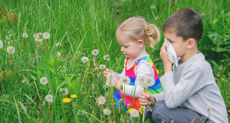 Blowing on a dandelion. Seasonal allergy in a child. Running noseの写真素材