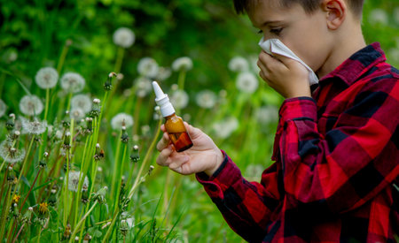 The boy is blowing on a dandelion. Seasonal allergies.の写真素材