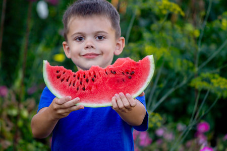 Boy eating delicious watermelon on nature background.Summerの写真素材