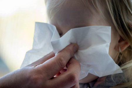 Close-up of a little girl with a cold virus, snot. Selective focus.の写真素材