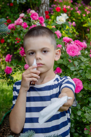 Child Sneezing from Flower Allergy. Selective focus.の写真素材