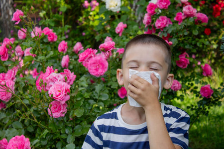 Child Sneezing from Flower Allergy. Selective focus.の写真素材