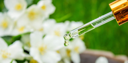 Jasmine essential oil in a glass bottle and jasmine flowers. Oilsの写真素材