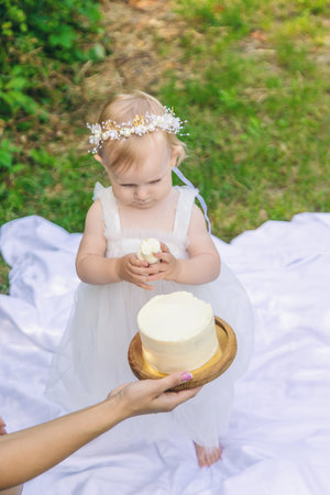 Little girl's first birthday. Mom holds cake. Celebrationの写真素材