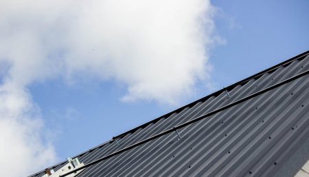 A man is installing solar panel mounts on the roof. Selective focus.の写真素材