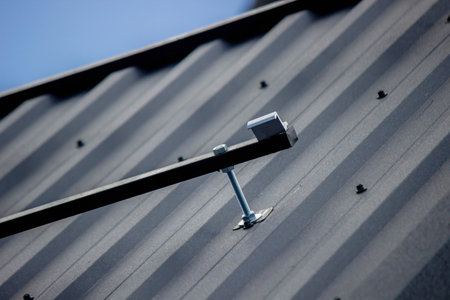 A man is installing solar panel mounts on the roof. Selective focus.の写真素材