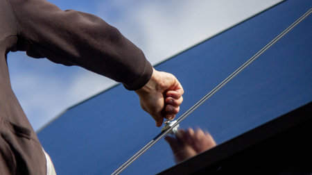 A man is installing solar panels on a roof. Selective focus.
