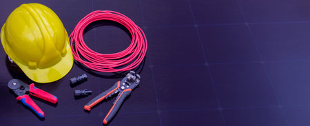 Solar Installation Tools and Safety Equipment on Solar Panel Surface.