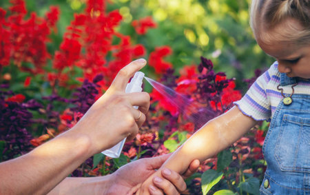 Dad sprays his child with mosquito repellentの写真素材
