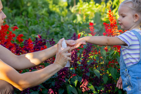 A mother sprays her child with mosquito repellentの写真素材