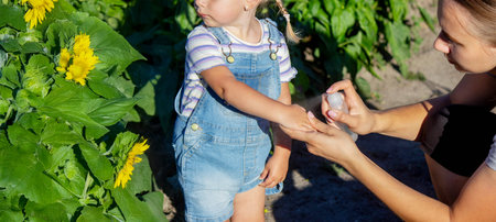 A mother sprays her child with mosquito repellentの写真素材