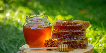 fresh honey on a background of garden and flowers. Selective focus.