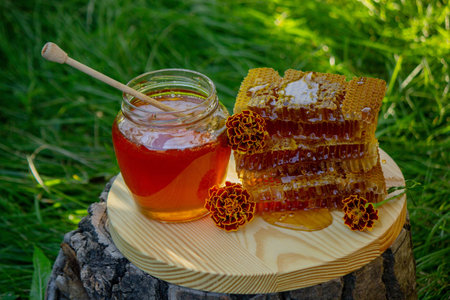fresh honey on a background of garden and flowers. Selective focus.