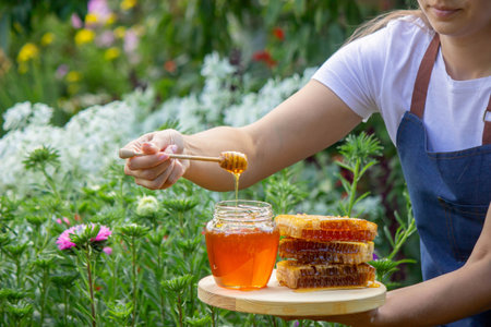 Fresh honey in jar with honeycomb and dipper outdoors.の写真素材