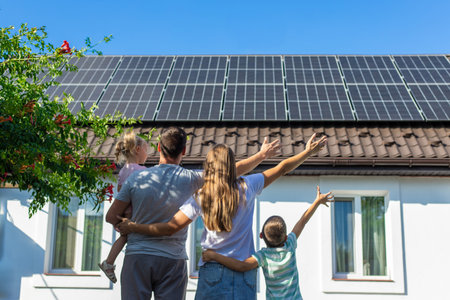 happy family on the background of a house with solar panels on the roof. Selective focus.の写真素材