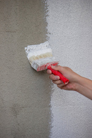 Painting a Wall with Brush and White Paint.の写真素材