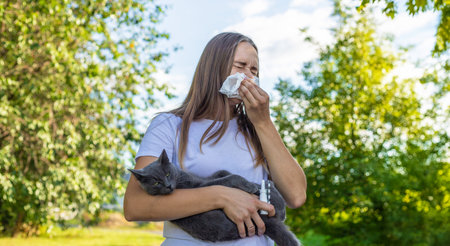 Woman holding a cat. Woman is allergic to cats. Allergy to cat furの写真素材