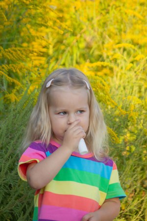 Girl in rainbow shirt with ragweed allergy.の写真素材