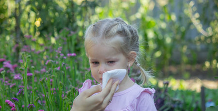 Sad little girl with allergy symptoms outdoors.の写真素材