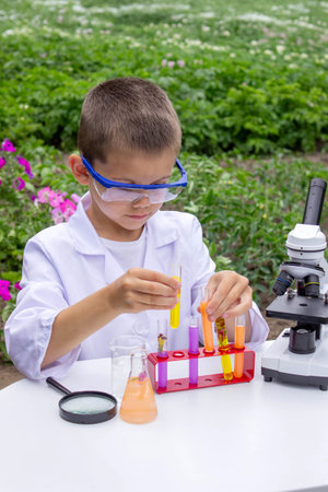 Boy conducting science experiments. Child with microscope.の写真素材