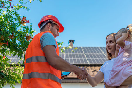 Family with solar panels discussing installation with engineer.の写真素材