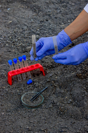 A scientist takes soil into a test tube for analysis. Selective focus