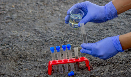 A scientist takes soil into a test tube for analysis.