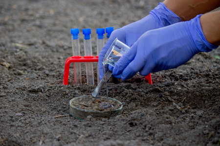 A scientist takes soil into a test tube for analysis. Selective focus