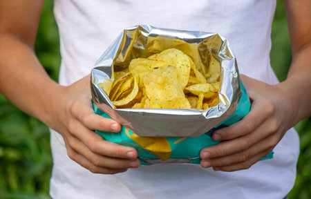 Boy eating chips from a pack. Unhealthy food concept.