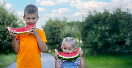 A boy and a girl are eating watermelon. Food.の写真素材