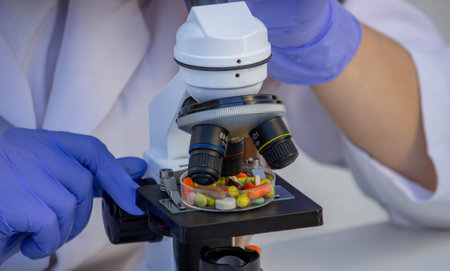 Pharmaceutical Research: Lab Technician Working with Medicine and a Microscope.