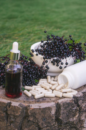 Different forms of natural elderberry medicine. Liquid extract in a bottle and capsules. Immunity.の写真素材