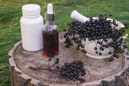 Different forms of natural elderberry medicine. Liquid extract in a bottle and capsules. Immunity.の写真素材
