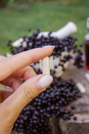 Different forms of natural elderberry medicine. Liquid extract in a bottle and capsules. Immunity.の写真素材