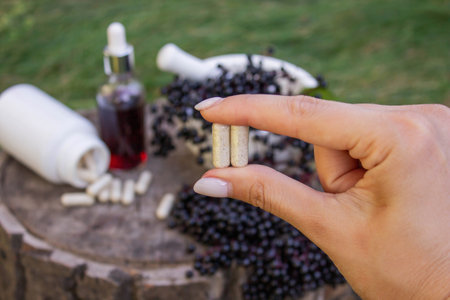 Different forms of natural elderberry medicine. Liquid extract in a bottle and capsules. Immunity.の写真素材