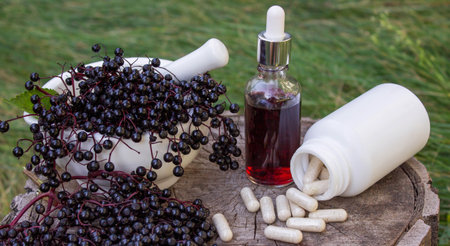Different forms of natural elderberry medicine. Liquid extract in a bottle and capsules. Immunity.の写真素材