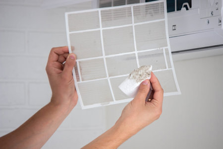 Air Conditioner Maintenance: Removing a Dirty Air Filter.