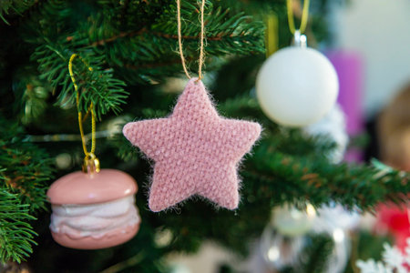 Knitted Pink Star and Macaron Ornament on the Christmas Tree.