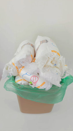Diapers Waste: Overflowing trash bin filled with used baby diapers.の写真素材