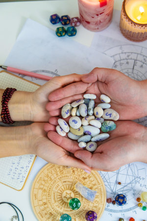 Two pairs of hands holding number stones. Numerology and divination ritualの写真素材