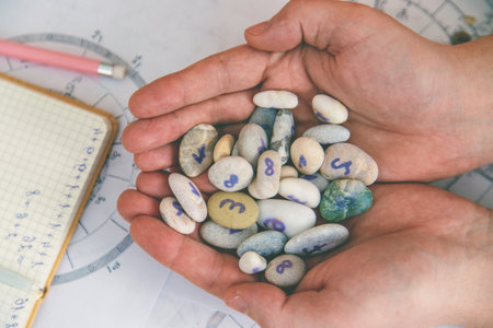 Numerology and divination with number stones in hands. Esotericism.の写真素材