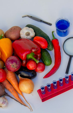 Test tubes and fresh vegetables on a lab table for nutritional research.の写真素材