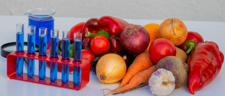 Microscope, test tubes, and fresh vegetables on a lab table for nutritional research.の写真素材