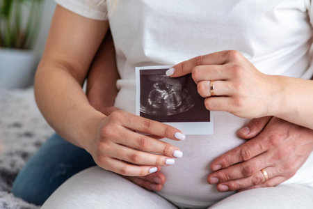 Pregnant woman with a man at home. Selective focus. Love.
