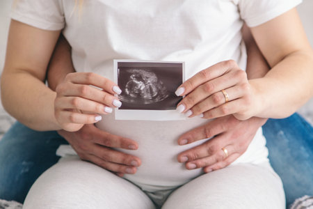 Pregnant woman with a man at home. Selective focus. Love.の写真素材