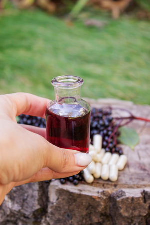 Elderberry berries, syrup, and herbal supplement capsules for natural cold and flu remedyの写真素材