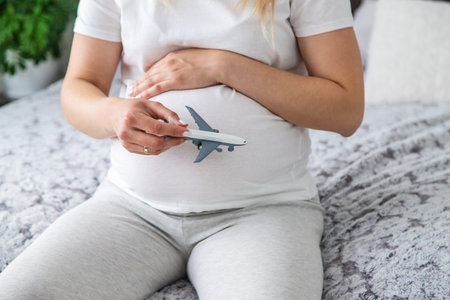 A pregnant woman plays with an airplane. Selective focus. Toy.の写真素材