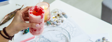Ceromancy wax divination ritual with astrological charts, crystals, and runes on a table.の写真素材