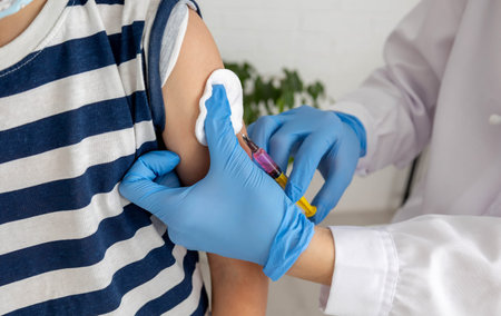 Doctor giving vaccination injection to patient's arm, vaccine and disease prevention.