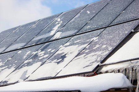 Solar panels covered with snow and ice in winter, renewable energy in frost